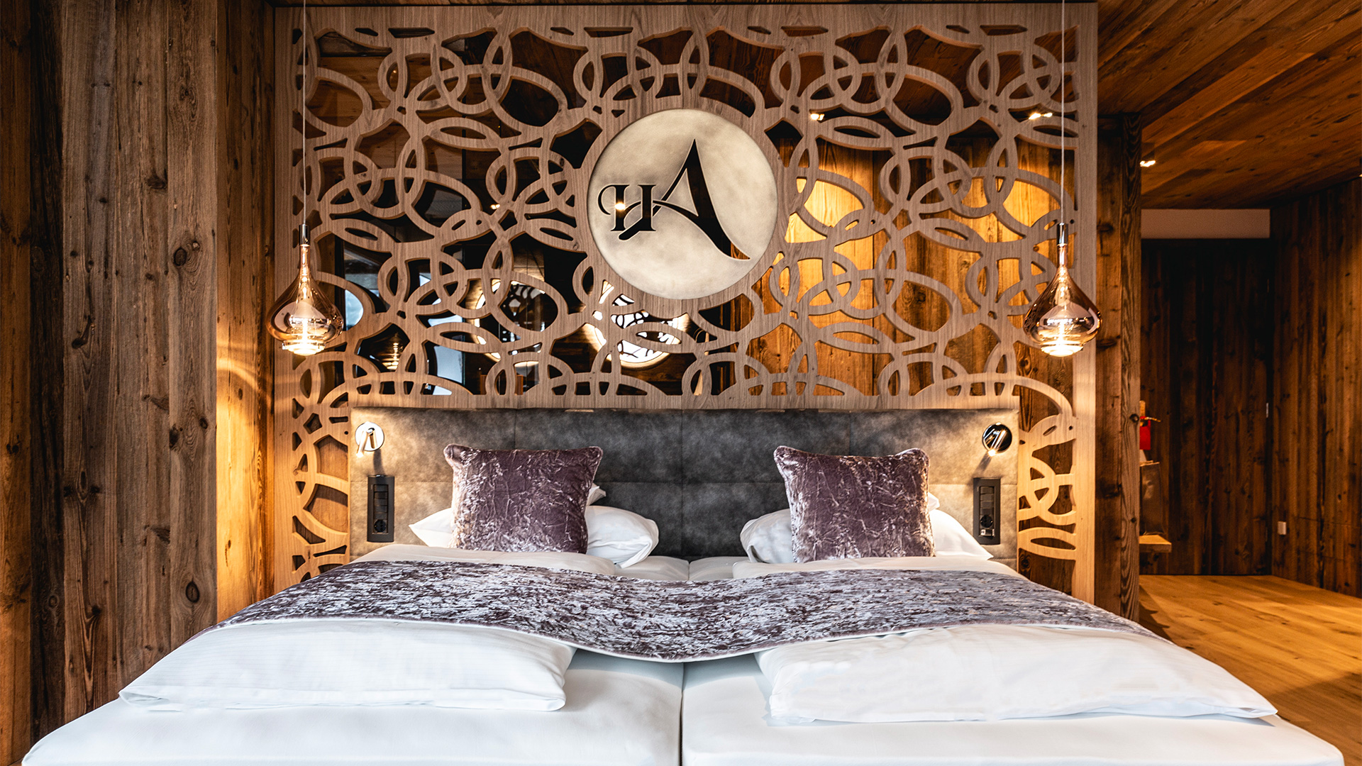 Doppelbett mit dekorativem Kopfteil aus geschnitztem Holz im Alpine Zimmer