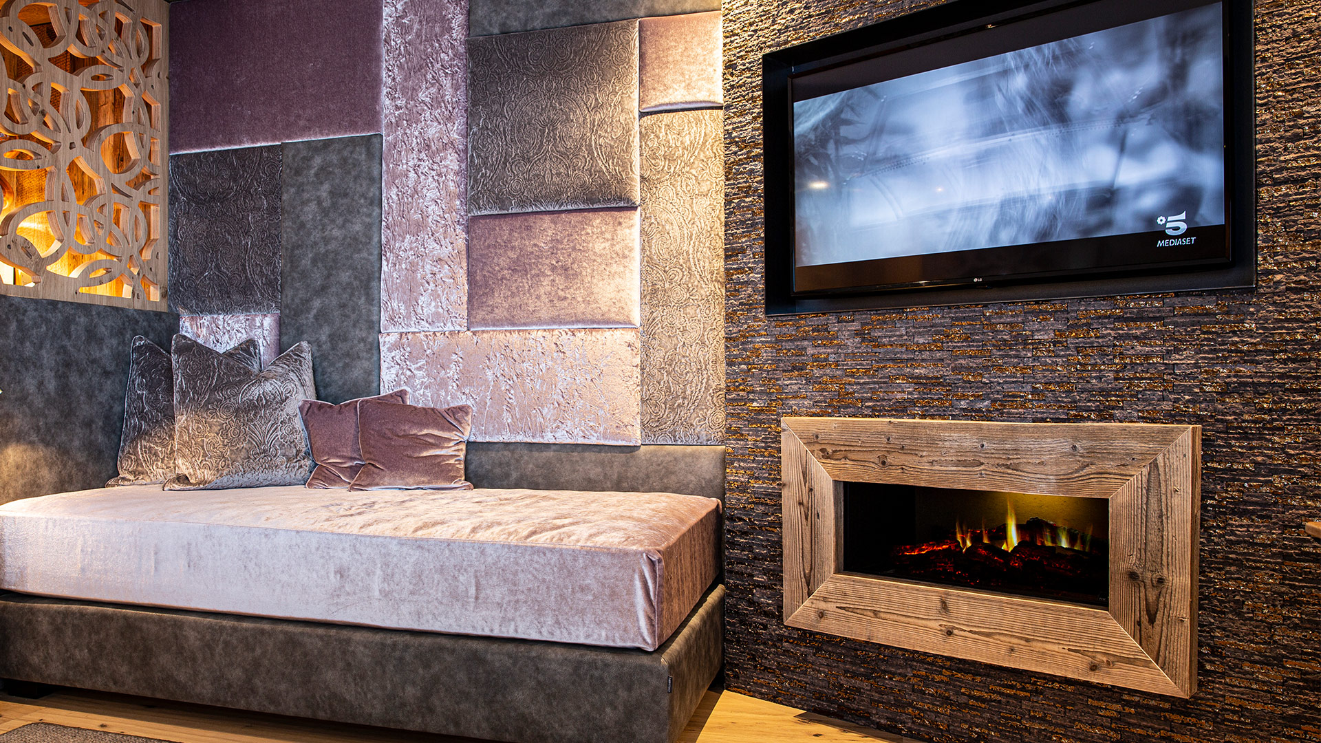 Gemütlicher Wohnbereich mit gepolstertem Sofa, Flammen-Effekt-Kamin und dekorativer Wand