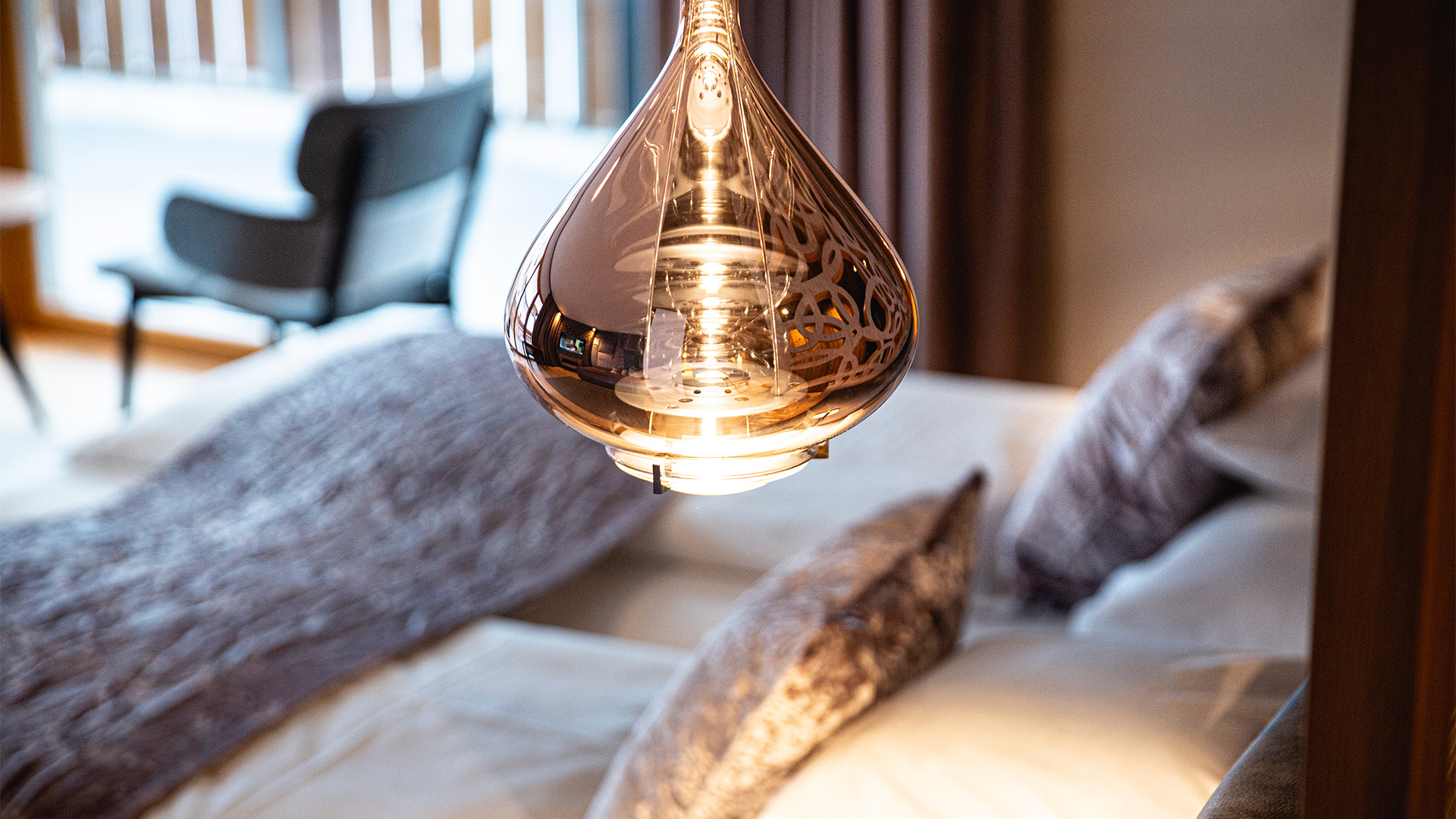Detail einer Design-Pendelleuchte über dem Bett in einem Hotelzimmer