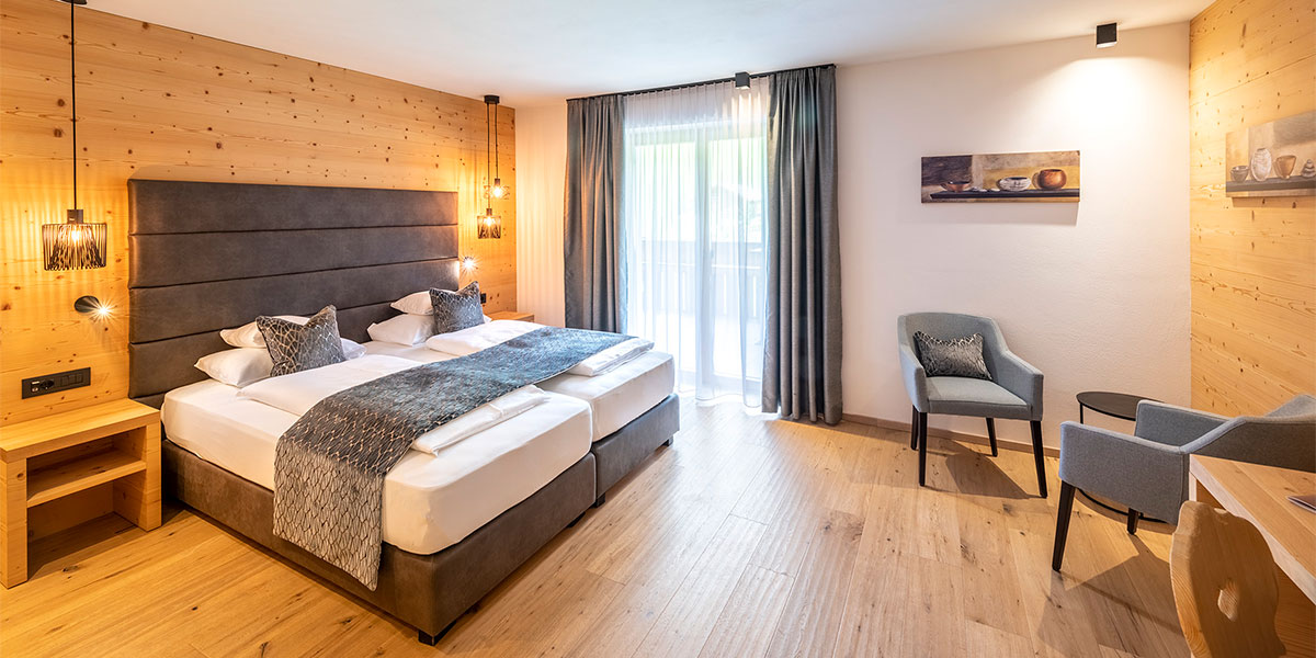 Innenansicht des Comfort Plus Zimmers mit trennbaren Betten und Wohnbereich