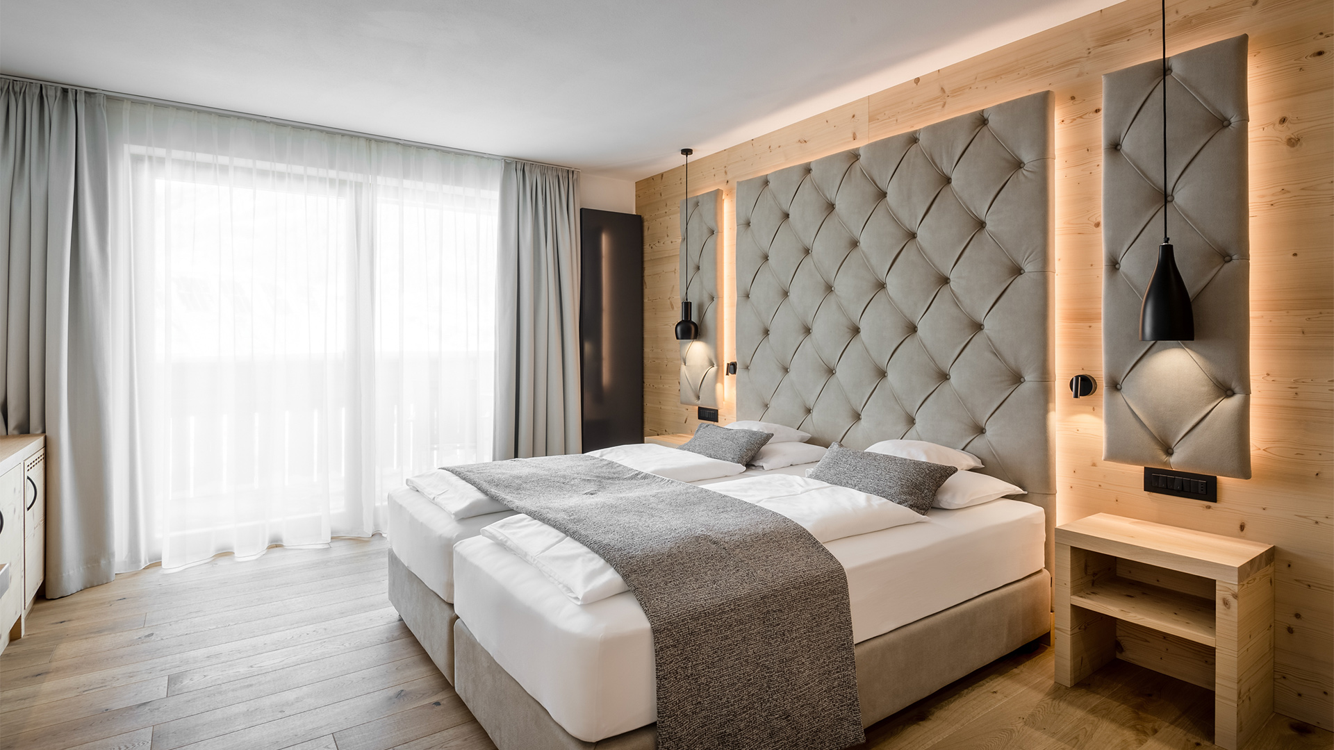 Gemütliches und raffiniertes Panorama-Zimmer im Hotel Arkadia, ausgestattet mit Balkon und Blick auf Sassongher und Ciampac.