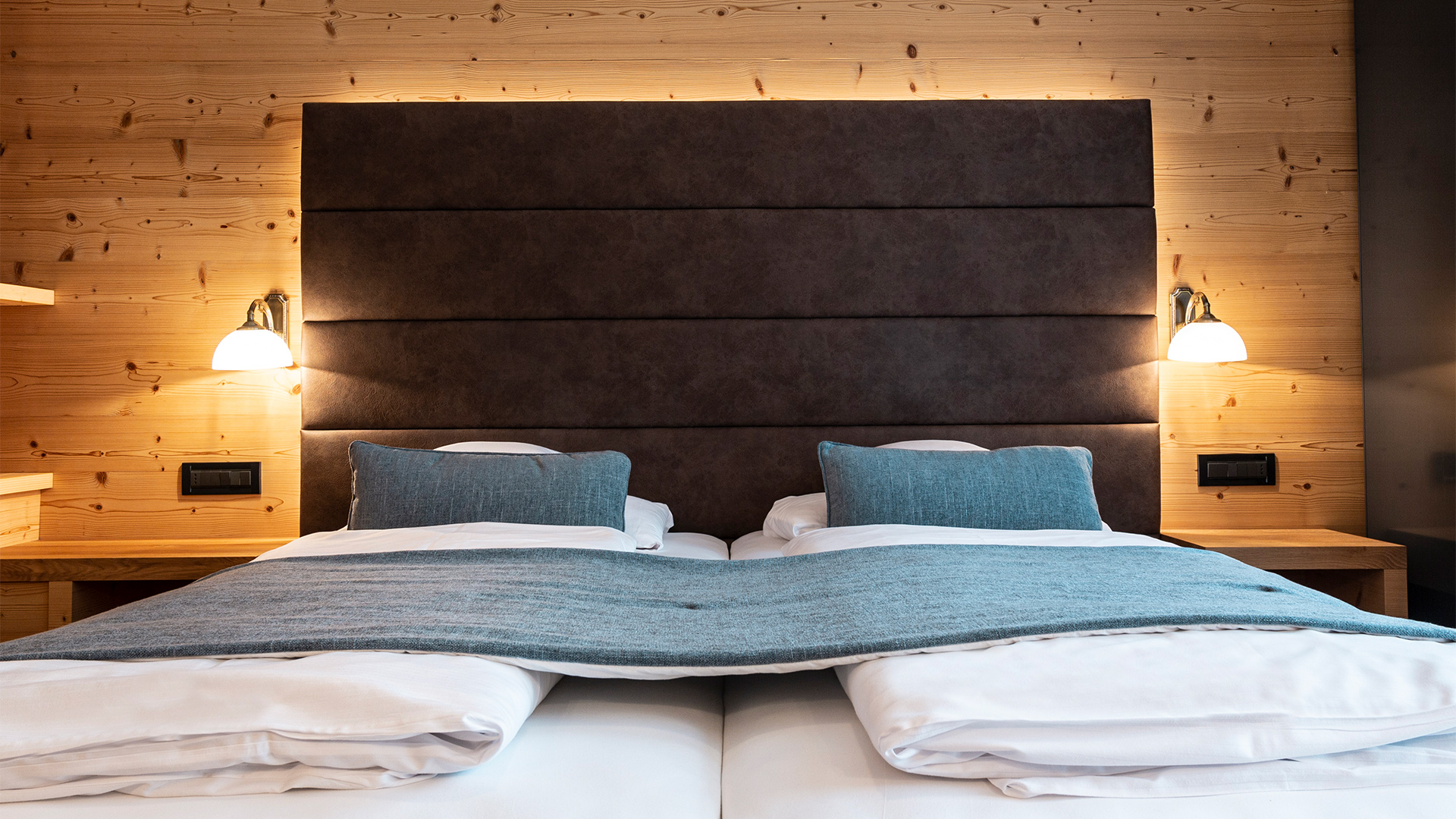 Gemütliches Panorama-Zweibettzimmer mit Einzelbetten, weißer Bettwäsche und warmen Holzwänden