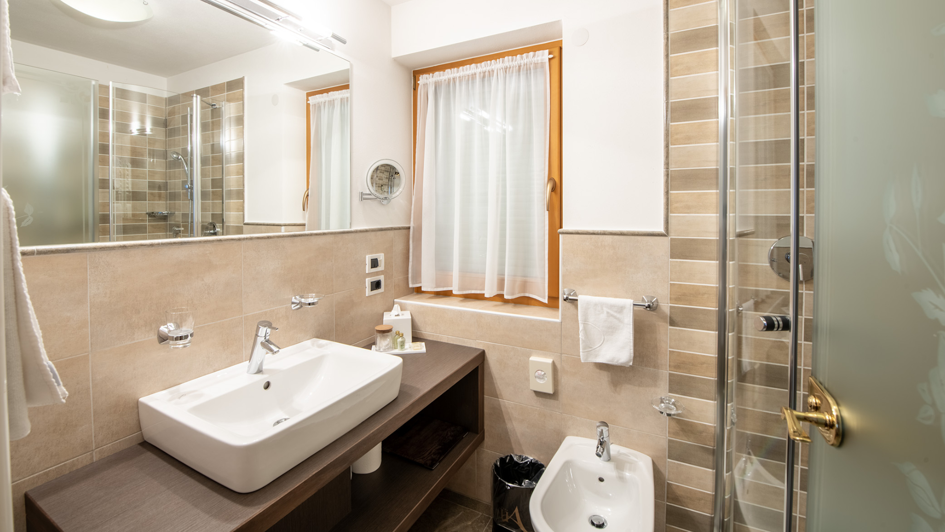 Privates Badezimmer des Einzelzimmers mit Waschbecken, großem Spiegel und Fenster mit weißen Vorhängen