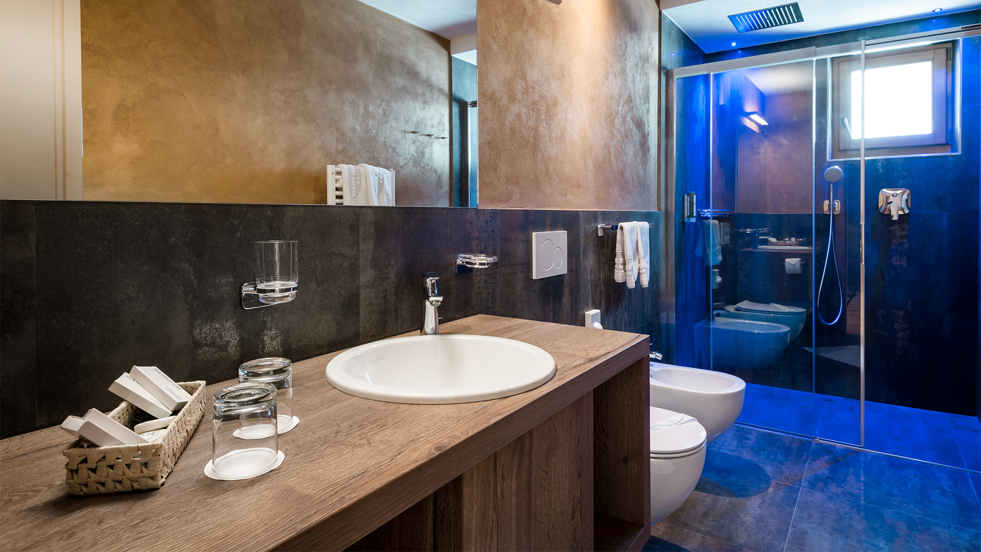 Modernes Badezimmer mit Holzwaschtisch, Waschbecken, Spiegel, Glasdusche, Bidet und WC